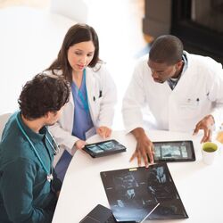 Doctors talking together with digital tablets and X-rays.